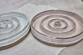 Hundinspiration handgjorda slow feed-matskålar i keramik med spiralmönster i puderrosa och linnevit glasyr.
