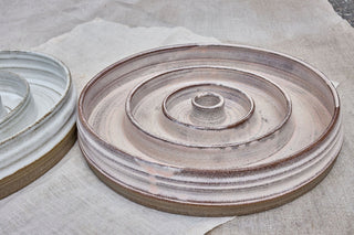 Hundinspiration handgjorda keramiska slow feed-matskålar i puderrosa och linnevit färg med spiralformad design.