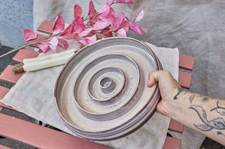 Hundinspiration handgjord keramisk slow feed-matskål i linnevit färg med spiralformad design för hundar.